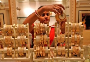 FILE PHOTO: A saleswoman shows gold bangles to a customer at a jewellery showroom, in Kolkata